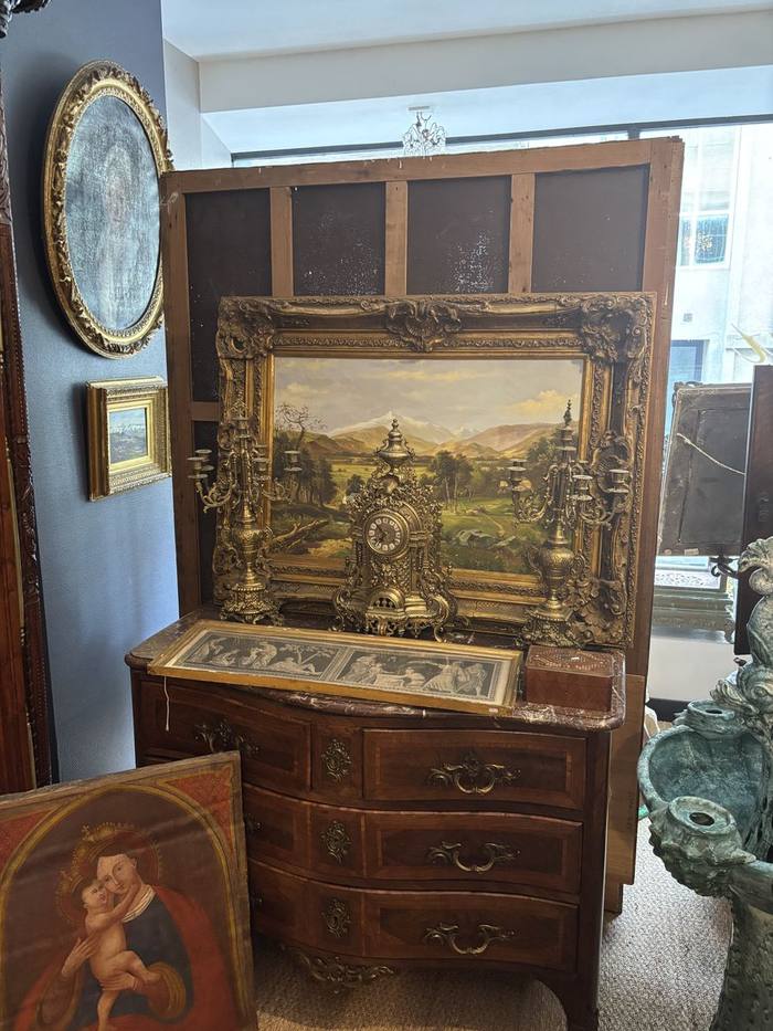 Commode ancienne, pendule et tableaux présentés côte à côte